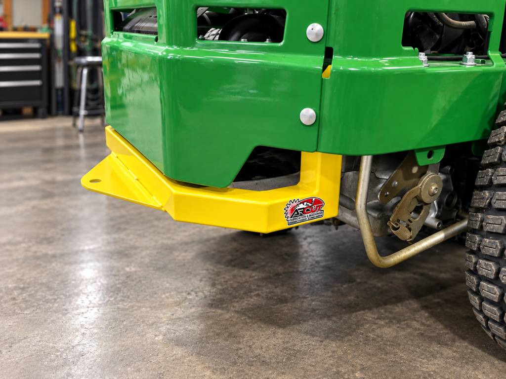 Yellow-painted front mount on a green John Deere mower.